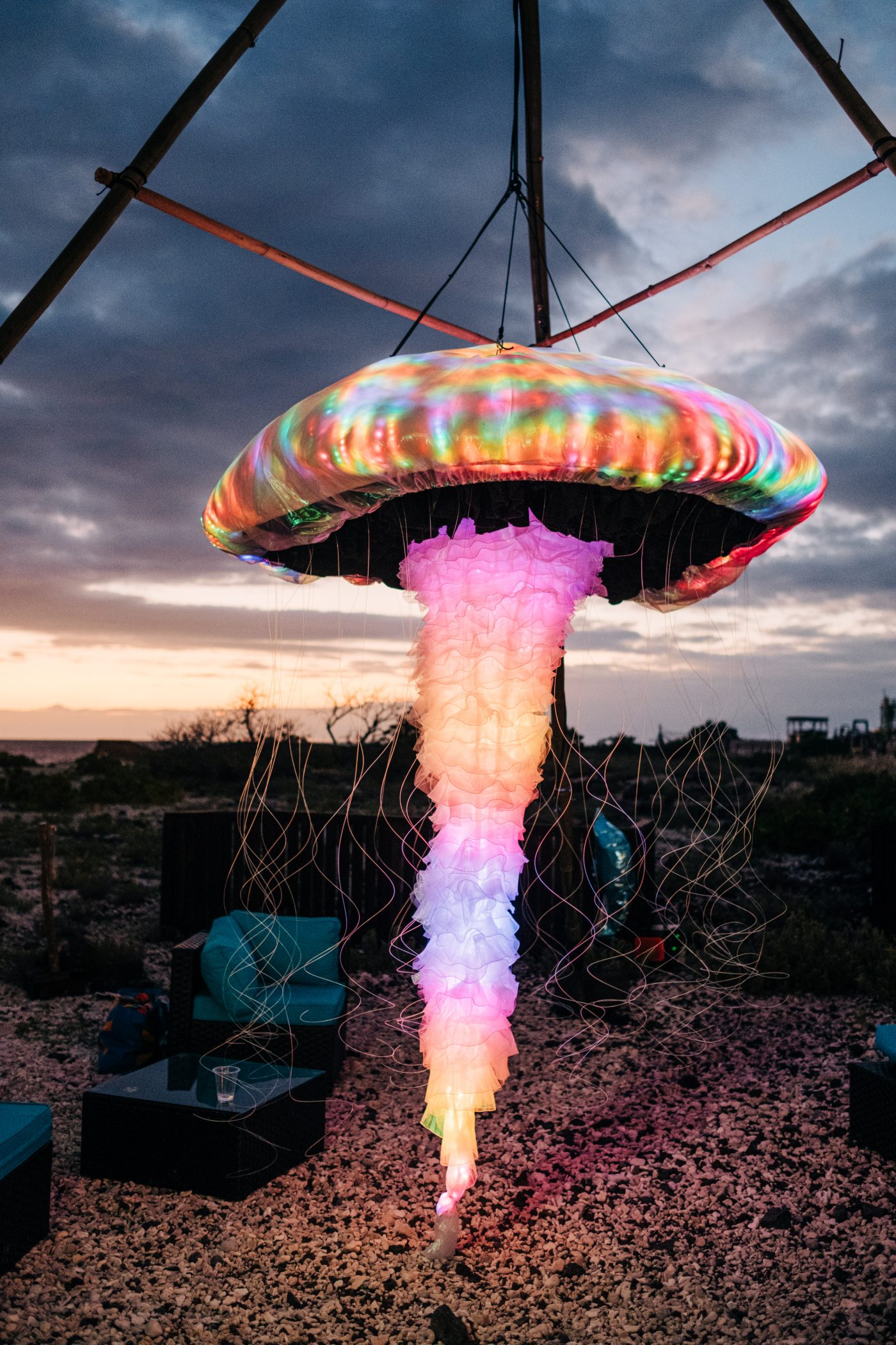 Close view of the LED jellyfish bell and ruffled oral arms glowing rainbow at dusk